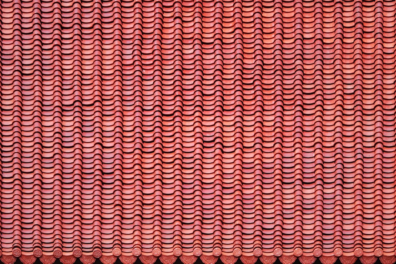 Close-up view of a uniform red clay roof tile pattern showcasing texture and design.